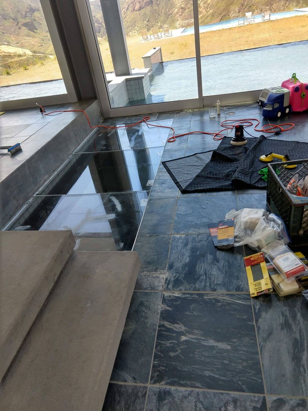 Floor renovation in a modern space with tools and materials scattered around.