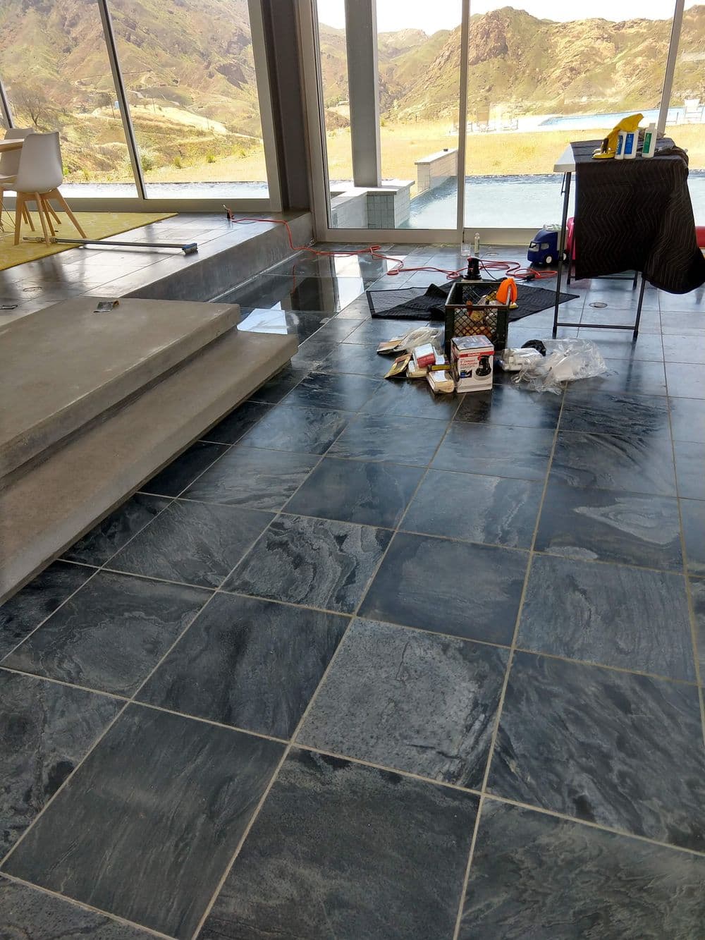 Modern interior with slate flooring, stairs, and home renovation tools in a bright space.