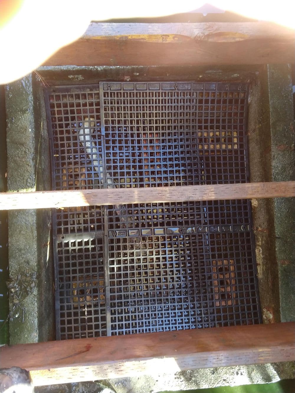 Grid structure with wooden supports over a water collection area.