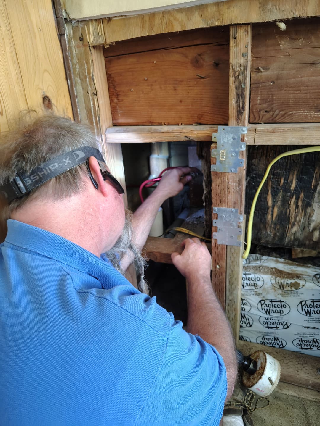 Electrician inspecting wiring in a home, focused on electrical connections and repairs.