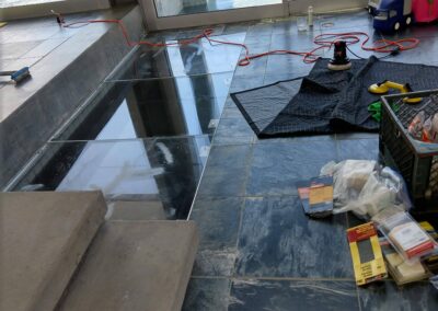 Floor renovation in a modern space with tools and materials scattered around.
