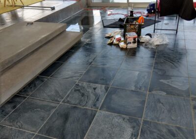 Modern interior with slate flooring, stairs, and home renovation tools in a bright space.