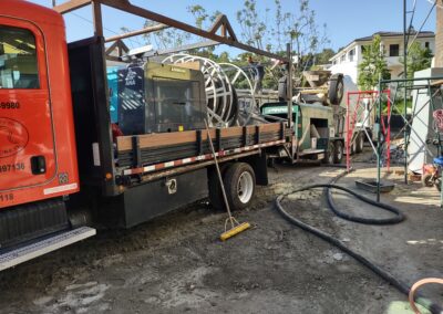 Construction site with heavy machinery, trucks, and equipment on a sunny day.